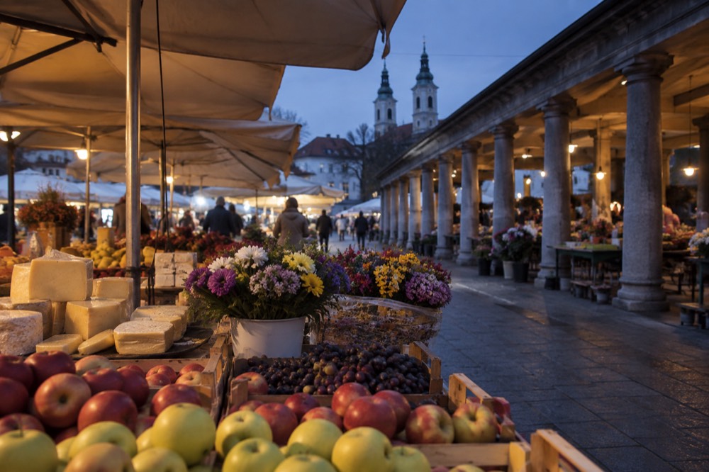 Market stalls with fruit, cheese and flowers beside the covered market colonnade in central Ljubljana