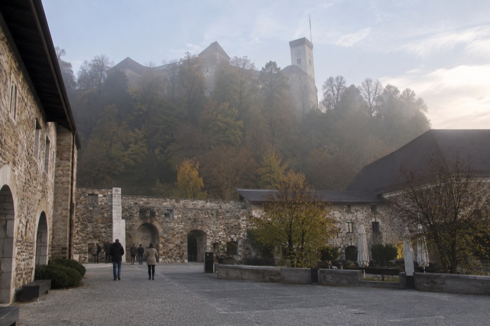 The clock tower of Ljubljana Castle seen from the courtyard below in late afternoon light