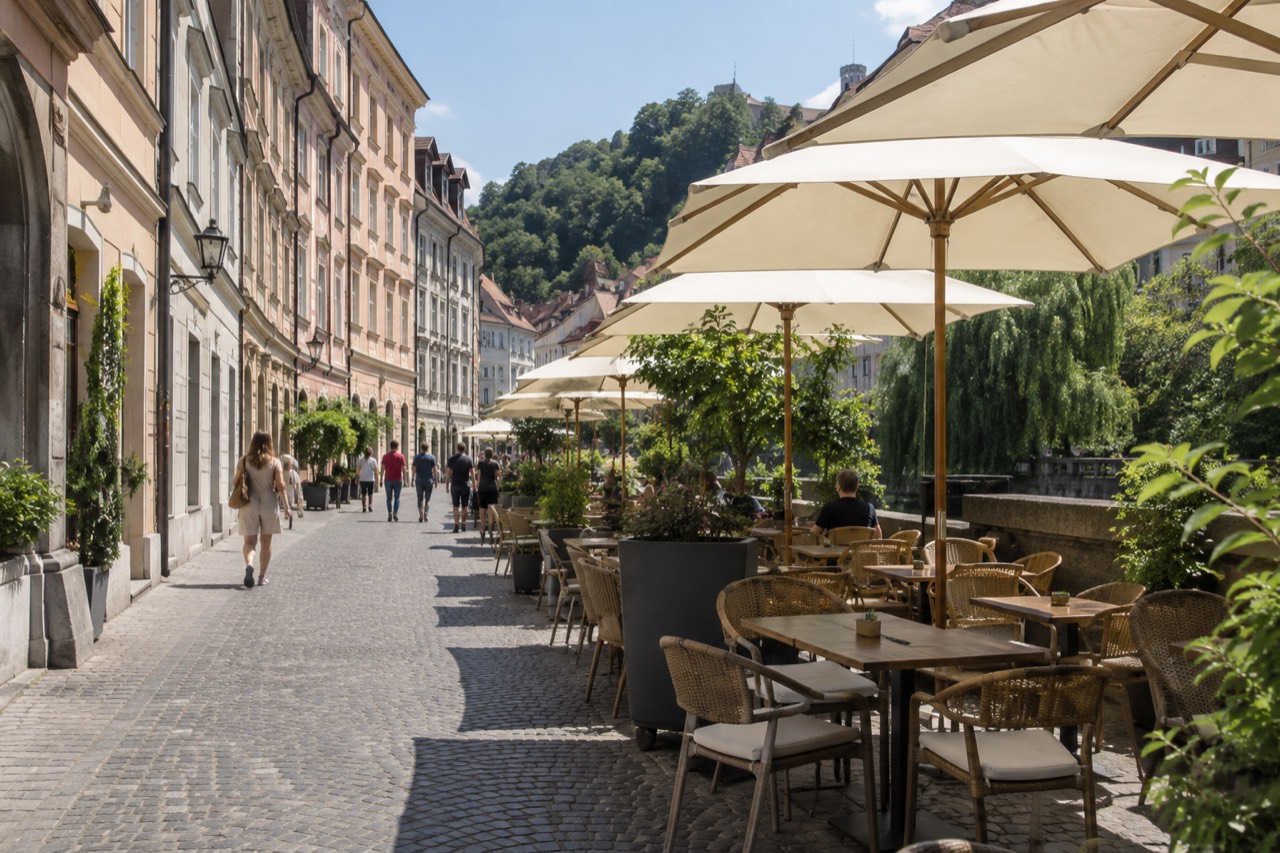 Café tables along a pedestrian street in central Ljubljana on a bright morning