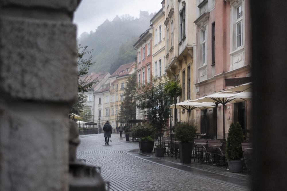 Pastel coloured buildings and café tables along the pedestrianised streets of Ljubljana old town