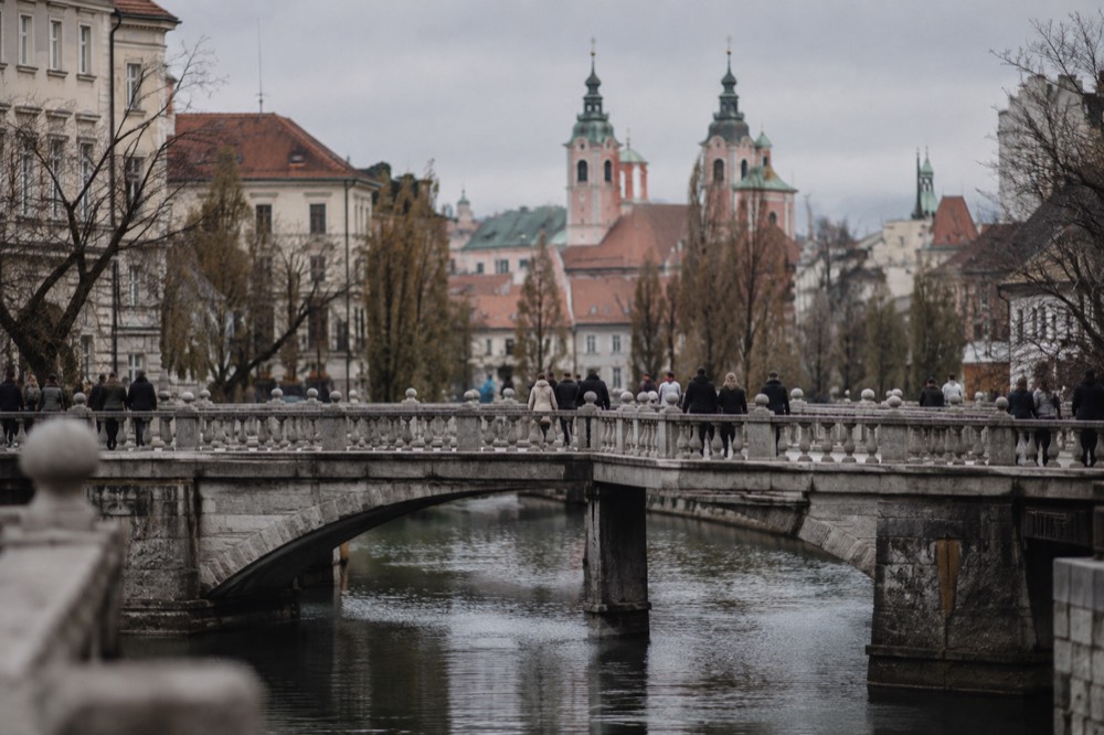 The Triple Bridge crossing the Ljubljanica river with the church spires of the old town behind it