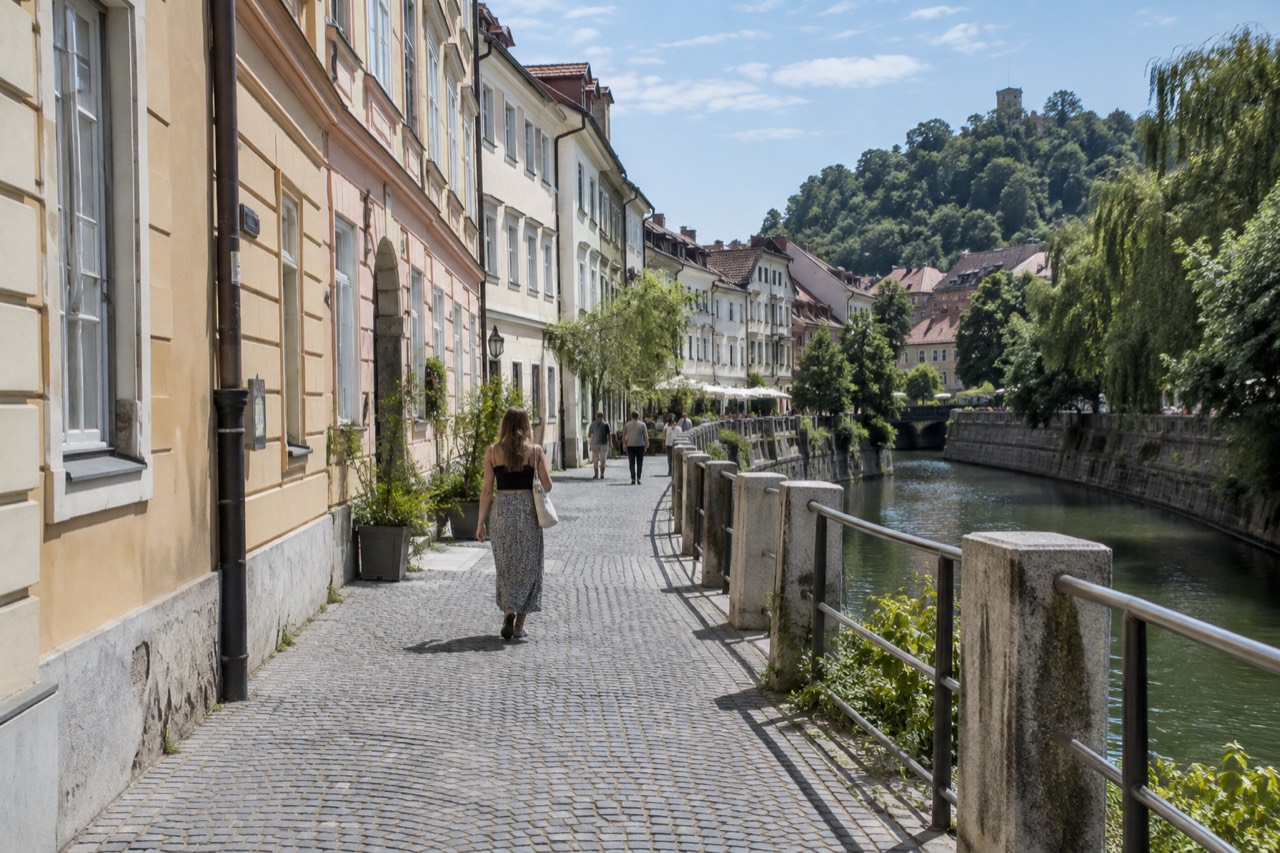 Pastel buildings and a riverside street in the pedestrian centre of Ljubljana on a bright morning