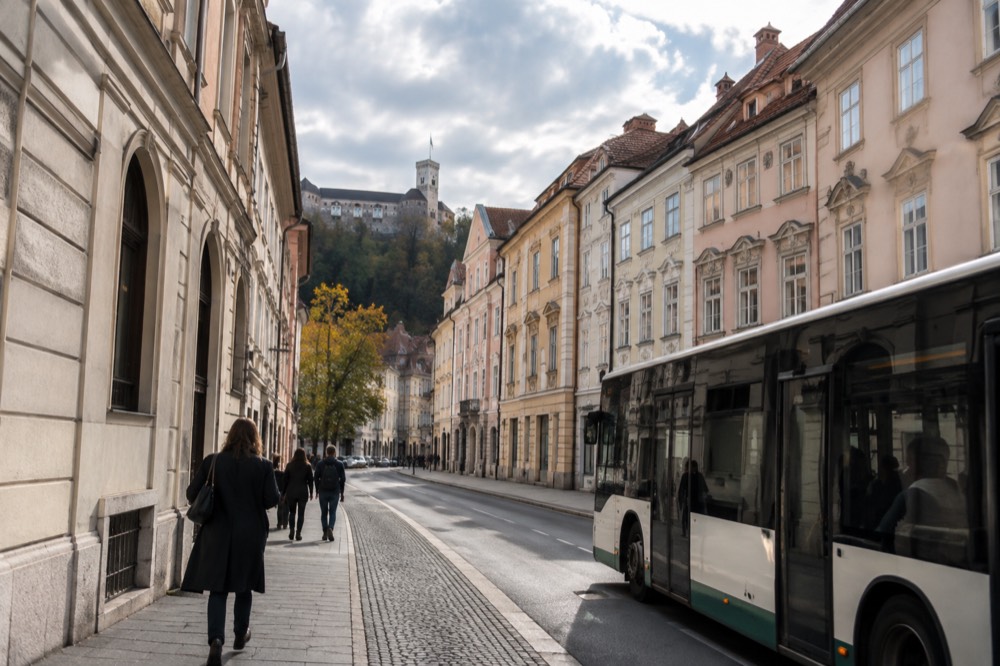 A city bus stopping on a Ljubljana street beside the pedestrian old centre