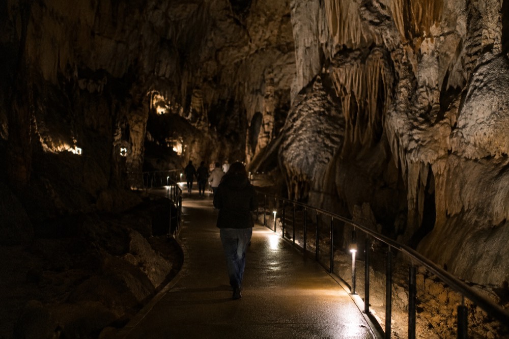 The underground path and lighting inside a large limestone cave chamber