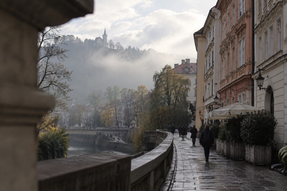 Morning fog filling a valley with a hilltop church standing above the mist line
