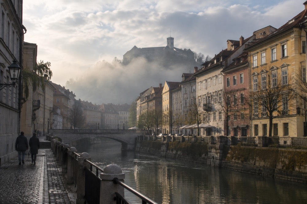 Morning fog filling a river valley with a hilltop castle rising above the mist
