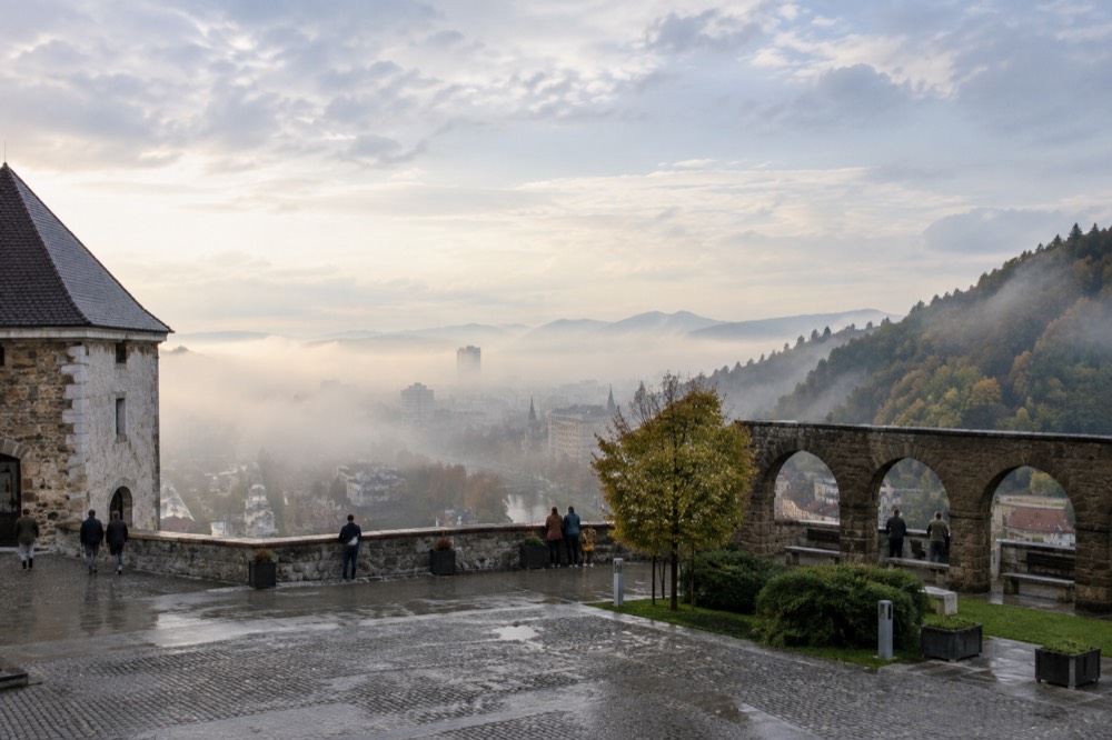 Morning mist over the Ljubljanica river with the castle hill emerging above it