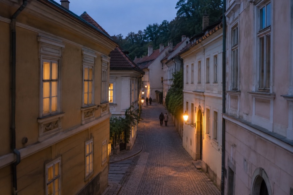 Narrow cobbled lane between old house facades leading uphill