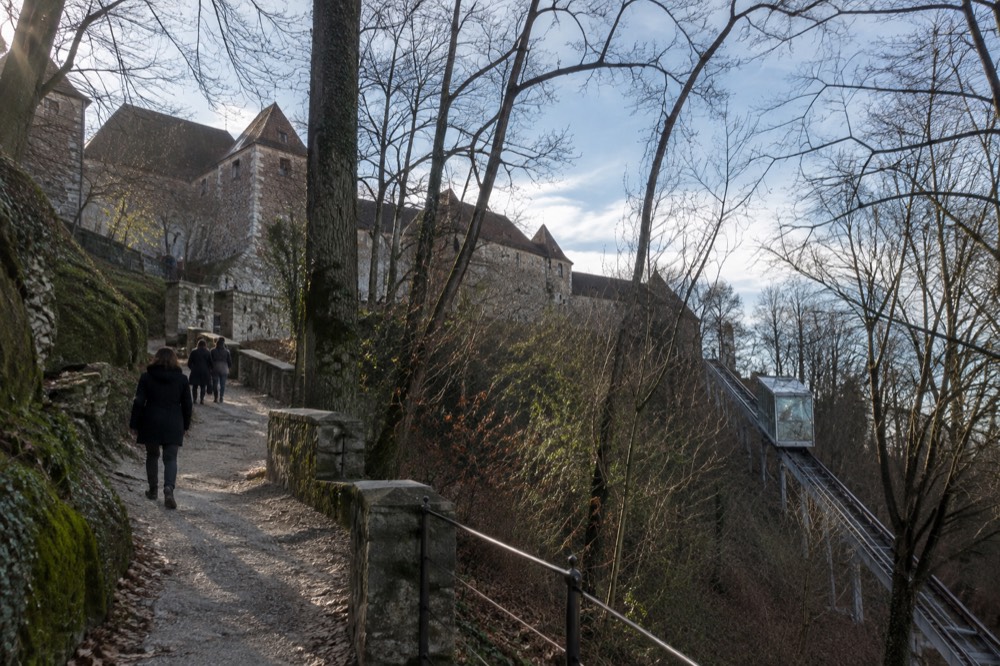 The stone and gravel footpath zigzagging up the wooded castle hill, with the funicular track visible alongside through the trees