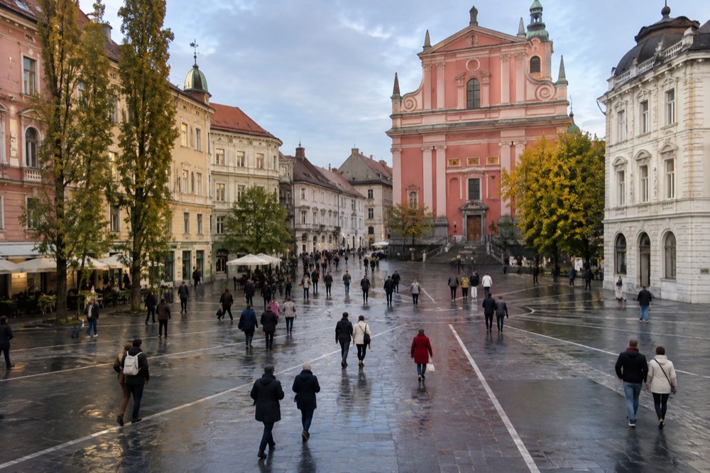 People crossing the car-free Prešeren Square towards the Franciscan Church in the late afternoon