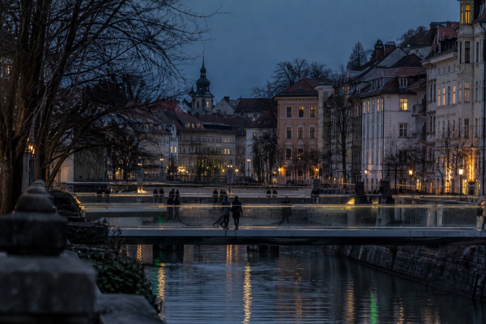 Three parallel footbridges crossing the Ljubljanica river towards the Old Town