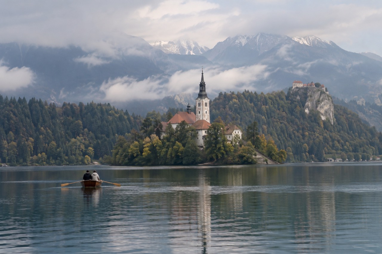Lake Bled with the island church and castle cliff above still morning water