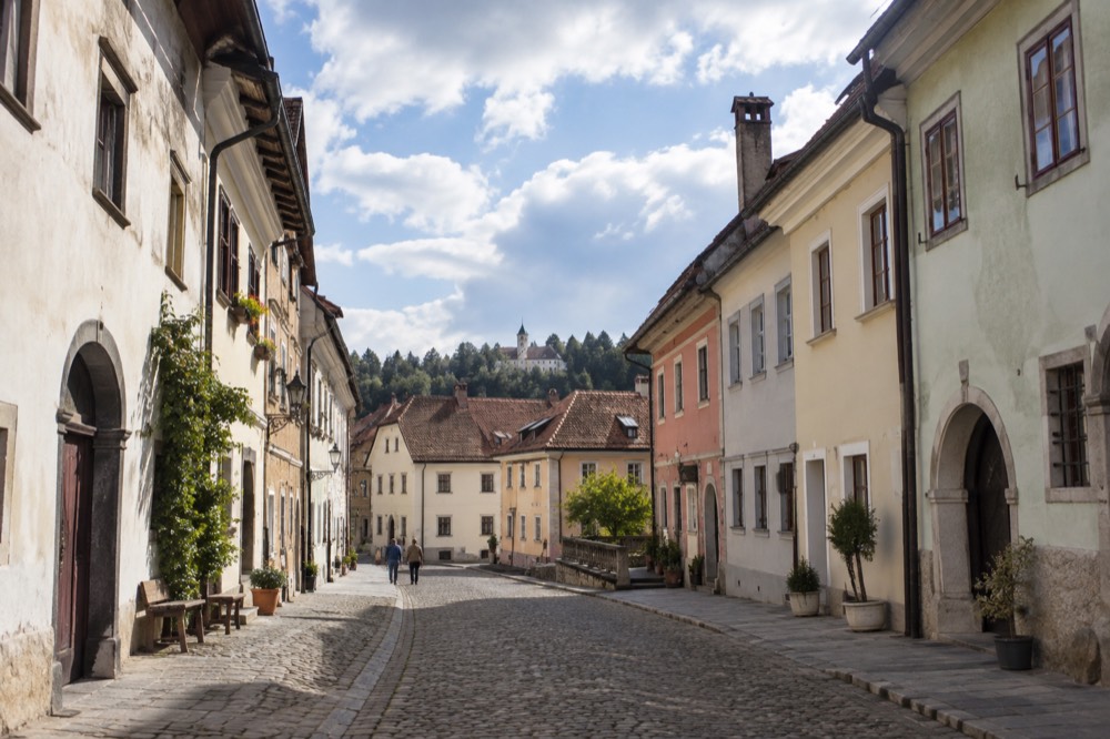 Pastel-coloured medieval houses along a cobbled street in Škofja Loka old town