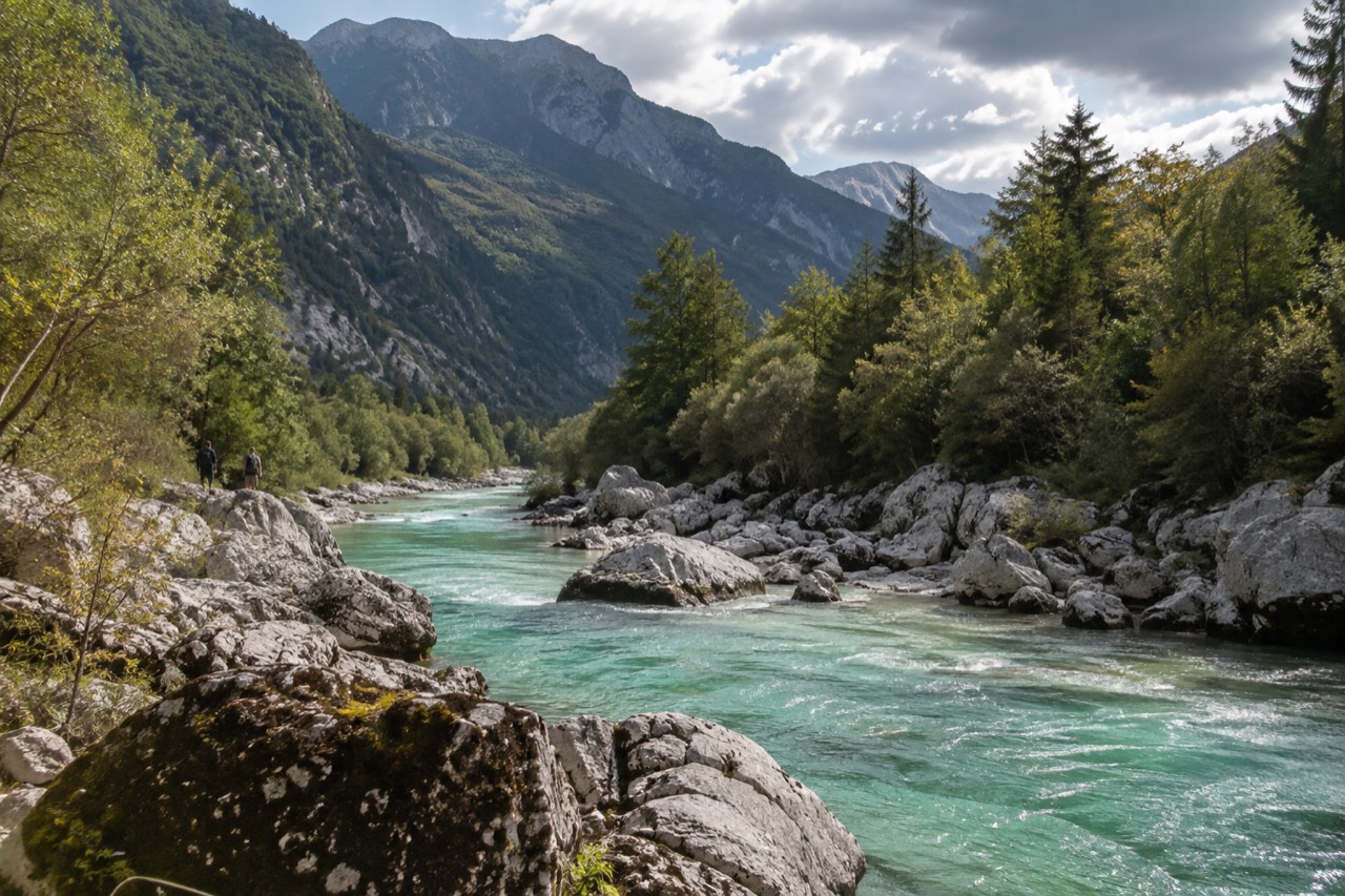 The emerald Soča River flowing between steep forested mountains near Bovec