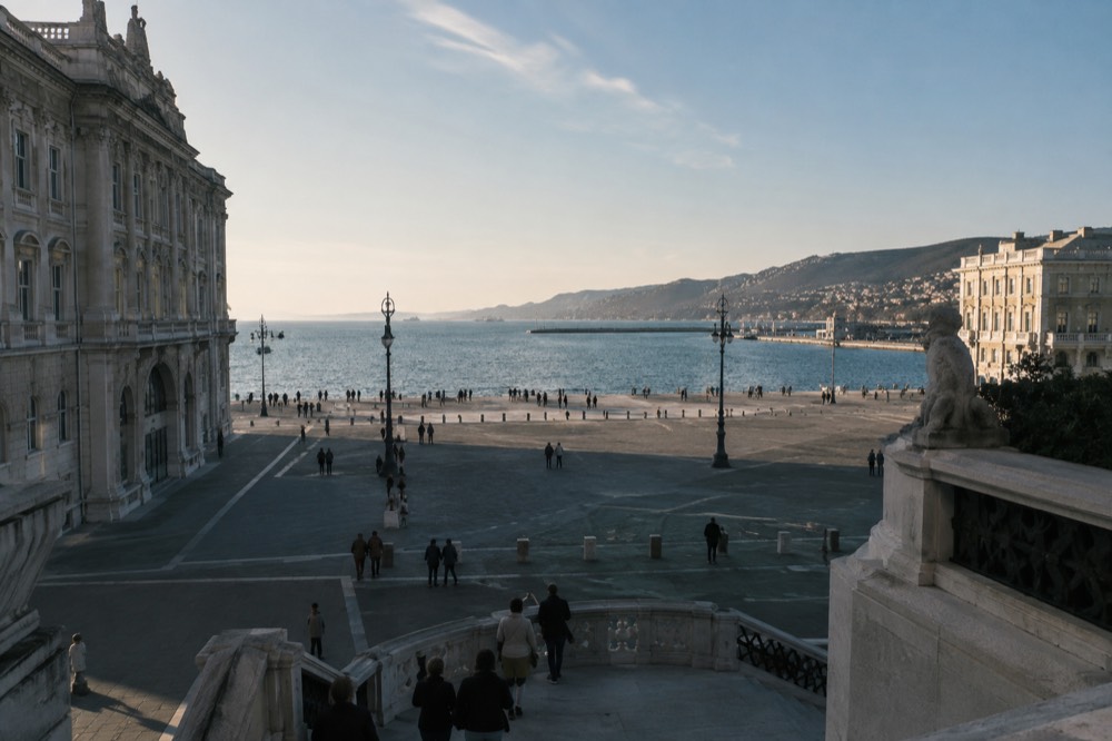 Seafront square in Trieste with historic buildings along the water