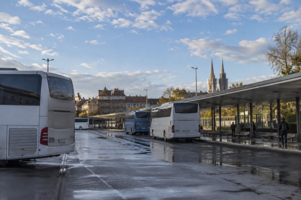 Coaches parked at a city bus station in the morning light