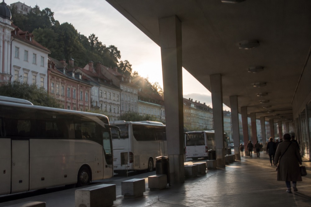 The covered walkway of the Ljubljana coach terminal with a departure board above the bays