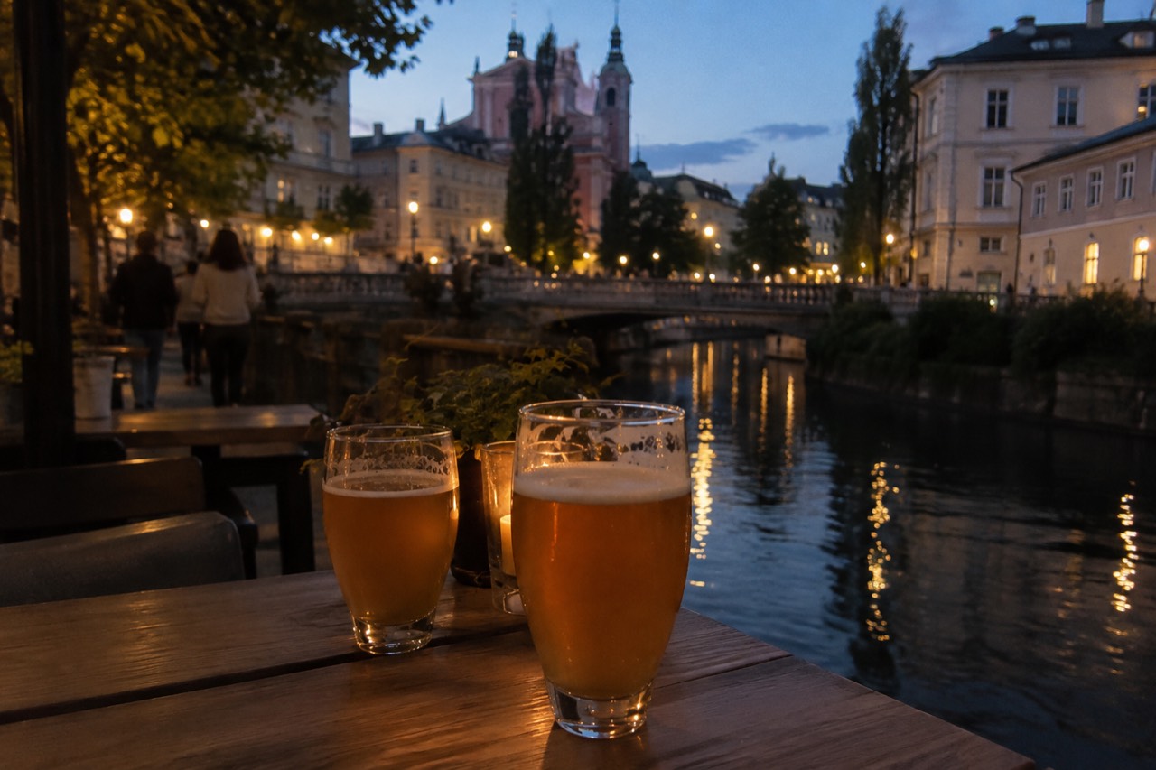 Glasses of craft beer on a wooden table beside the Ljubljanica river at dusk