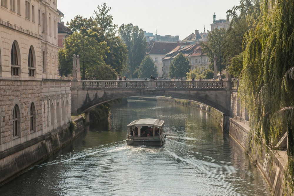 A river boat passing under one of the Ljubljanica bridges in central Ljubljana