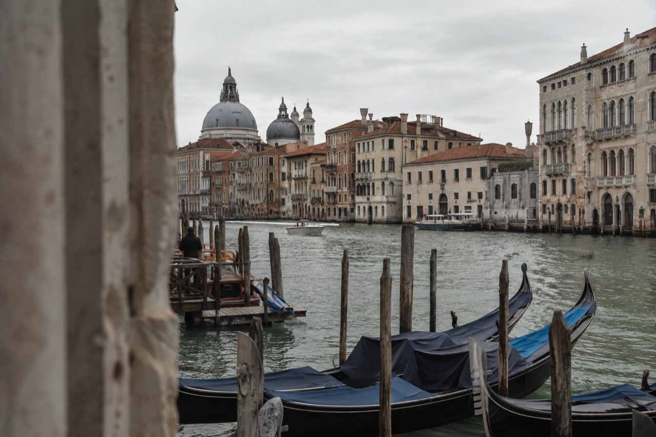 A canal in Venice with moored gondolas and old palazzi along the water