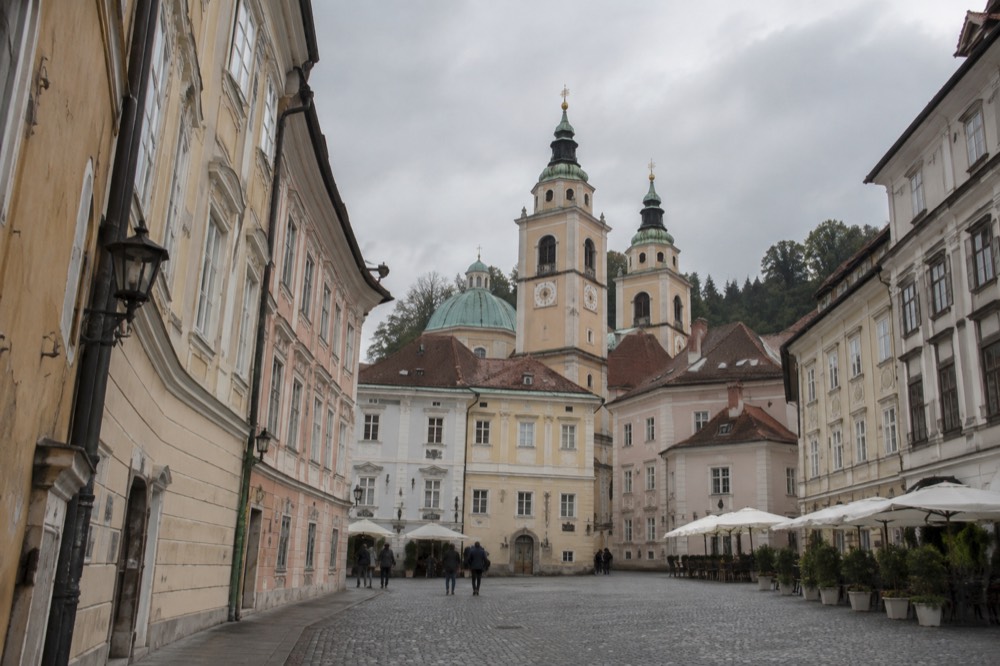 Cobbled square in the Ljubljana Old Town with baroque church towers above the rooftops