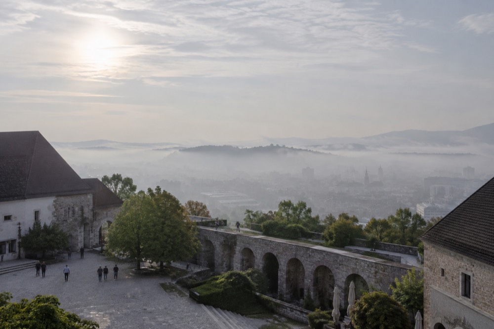 Morning fog sitting over the Ljubljana basin with the castle hill rising above the mist