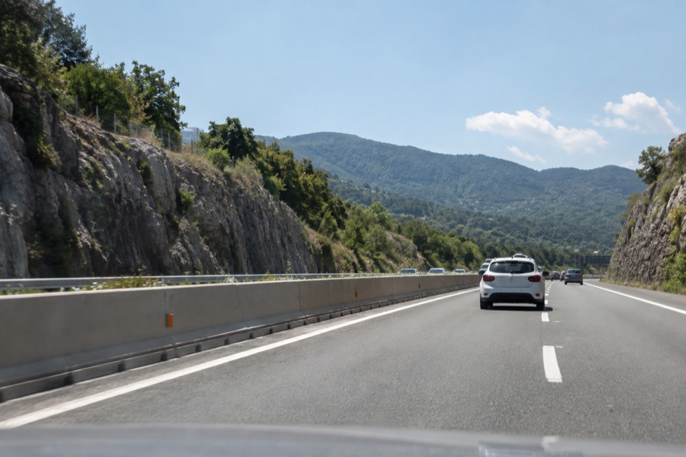 Motorway leading inland from the coast toward green hills