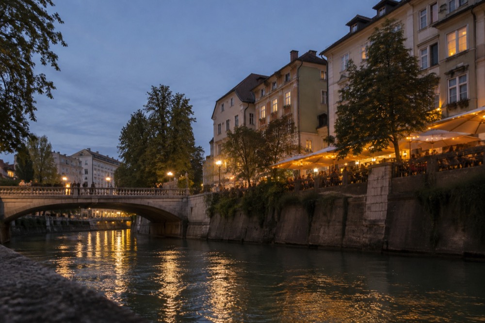 Riverside restaurants and the Ljubljanica embankment at dusk in central Ljubljana