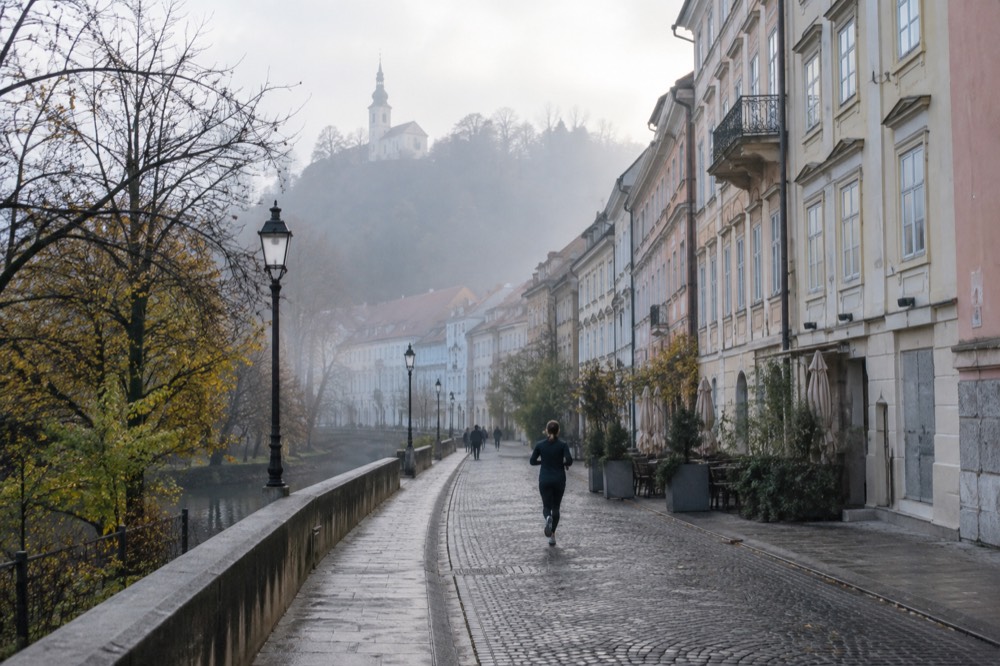 Morning mist over rooftops with a hilltop church above the fog line