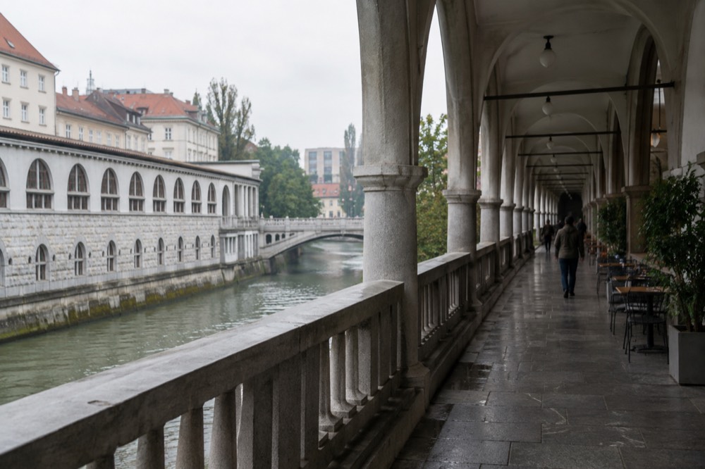 Arcaded riverside walkway beside the Ljubljanica in Ljubljana on a grey day