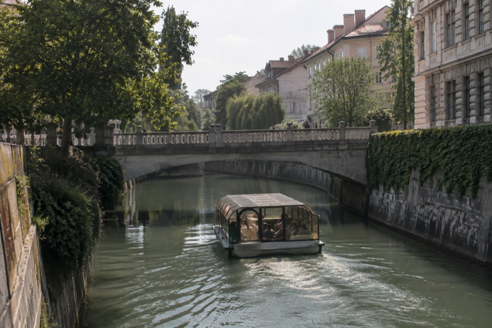 A river boat passing under one of the Ljubljanica bridges in the city centre