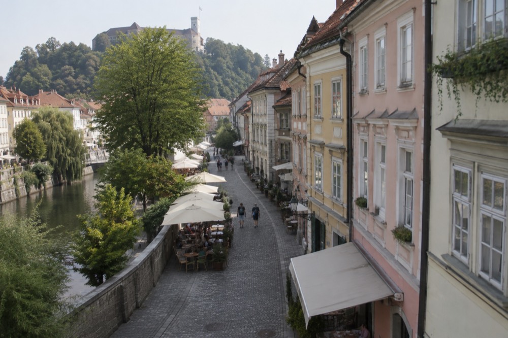 Cobblestone street in the old town with cafe tables and pastel building facades